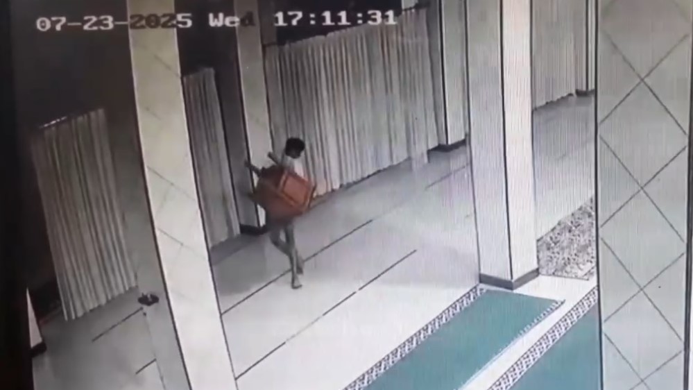 MALING: Seorang remaja tampak mencuri kotak amal masjid.