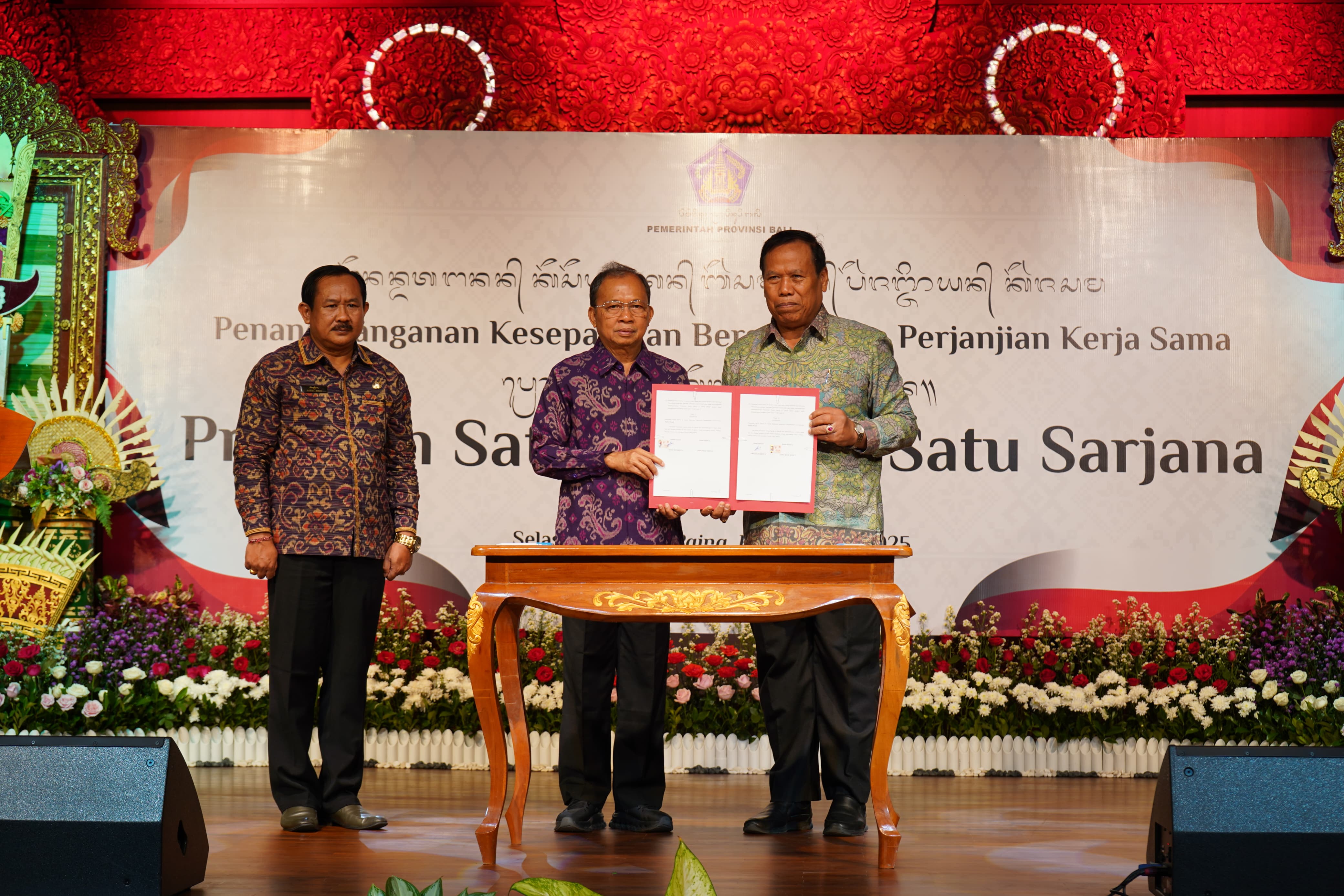 SATU KELUARGA SATU SARJANA: Gubernur Bali, Wayan Koster (baju ungu) menunjukkan MoU program satu keluarga satu sarjana di Bali.