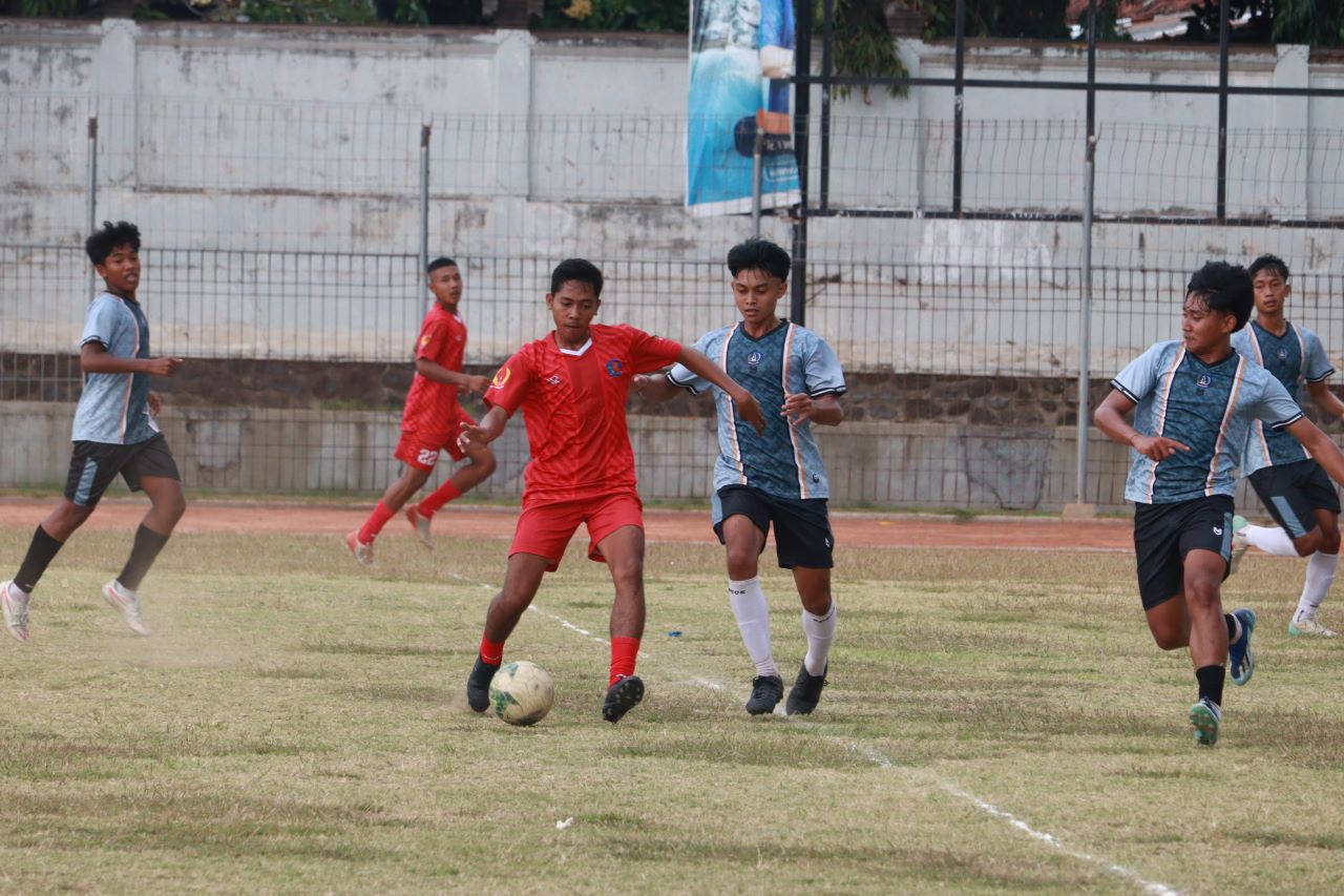 UJI COBA: Pemain sepakbola Buleleng (baju merah) membawa bola dalam pertandingan menghadapi tim sepakbola Badung (baju biru).
