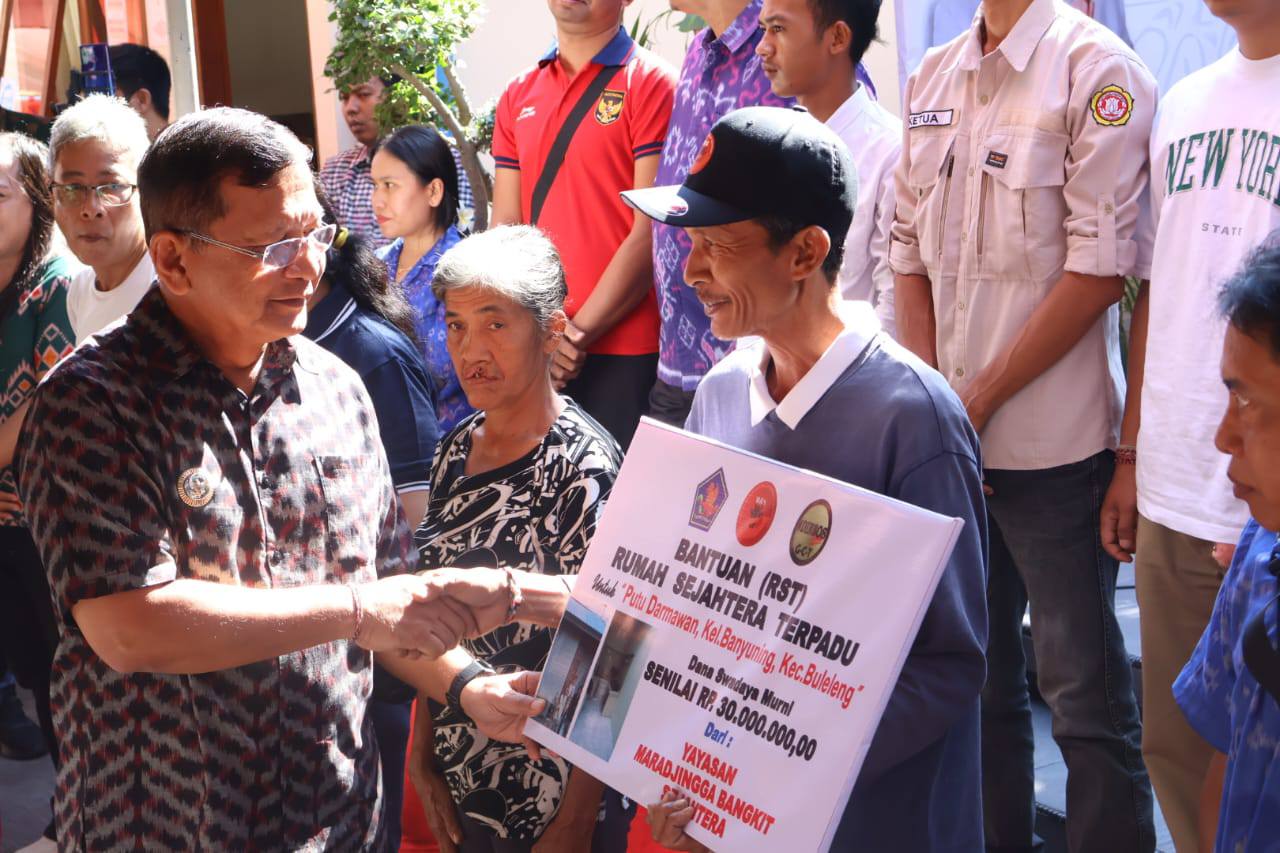SERAHKAN BANTUAN: Bupati Buleleng, I Nyoman Sutjidra (kiri) menyerahkan bantuan Rumah Sejahtera Terpadu kepada warga di Kelurahan Banyuning.