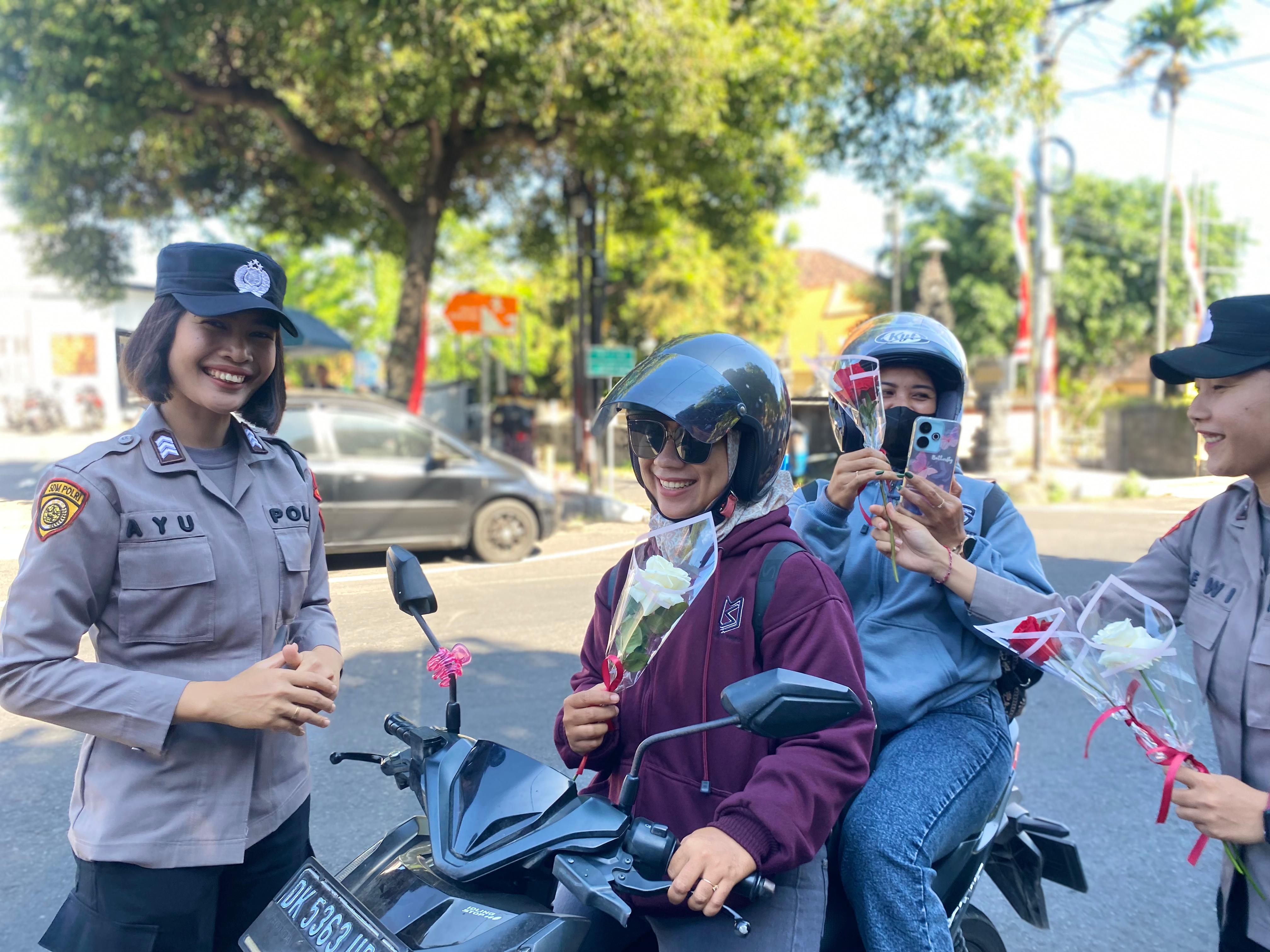 BAGI BUNGA: Polwan Polres Buleleng membagikan bunga dan bendera kepada pengguna jalan.