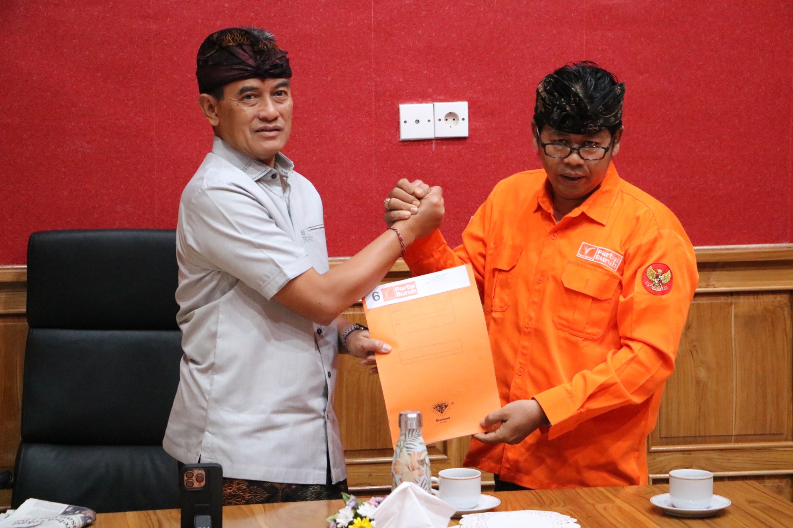 AJUKAN TUNTUTAN: I Gusti Ngurah Made Rediasa, Ketua Exco Partai Buruh Kabupaten Buleleng (kanan) menyerahkan poin tuntutan kepada Wakil Bupati Buleleng, Gede Supriatna.
