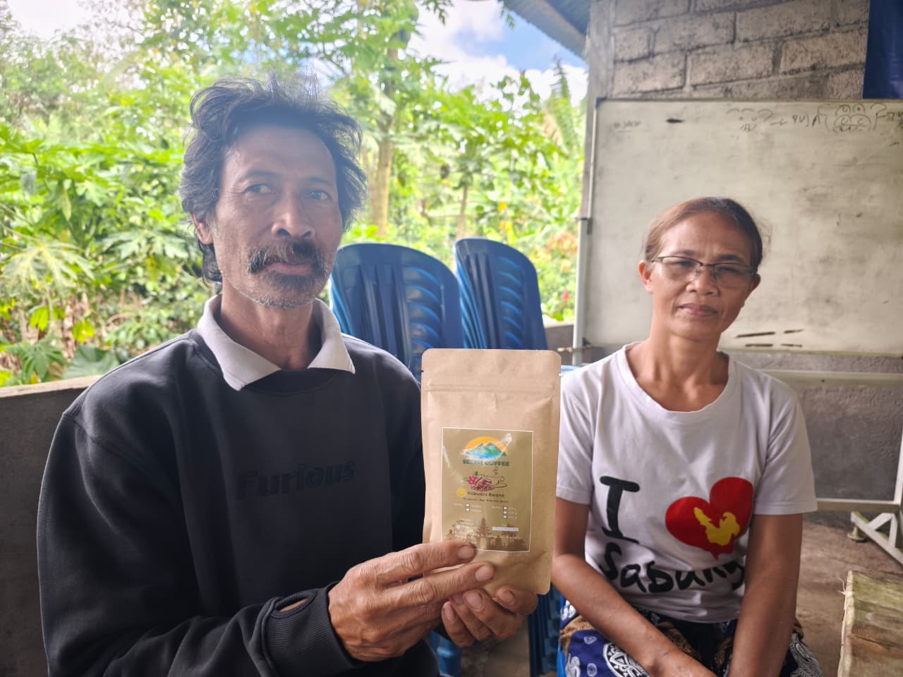 ROBUSTA MENDUNIA: Wayan Wardana (kiri) menunjukkan produk kopi segiri yang ia hasilkan. Lewat produk itu ia ingin menunjukkan bahwa kopi robusta tak kalah dengan kopi arabika.