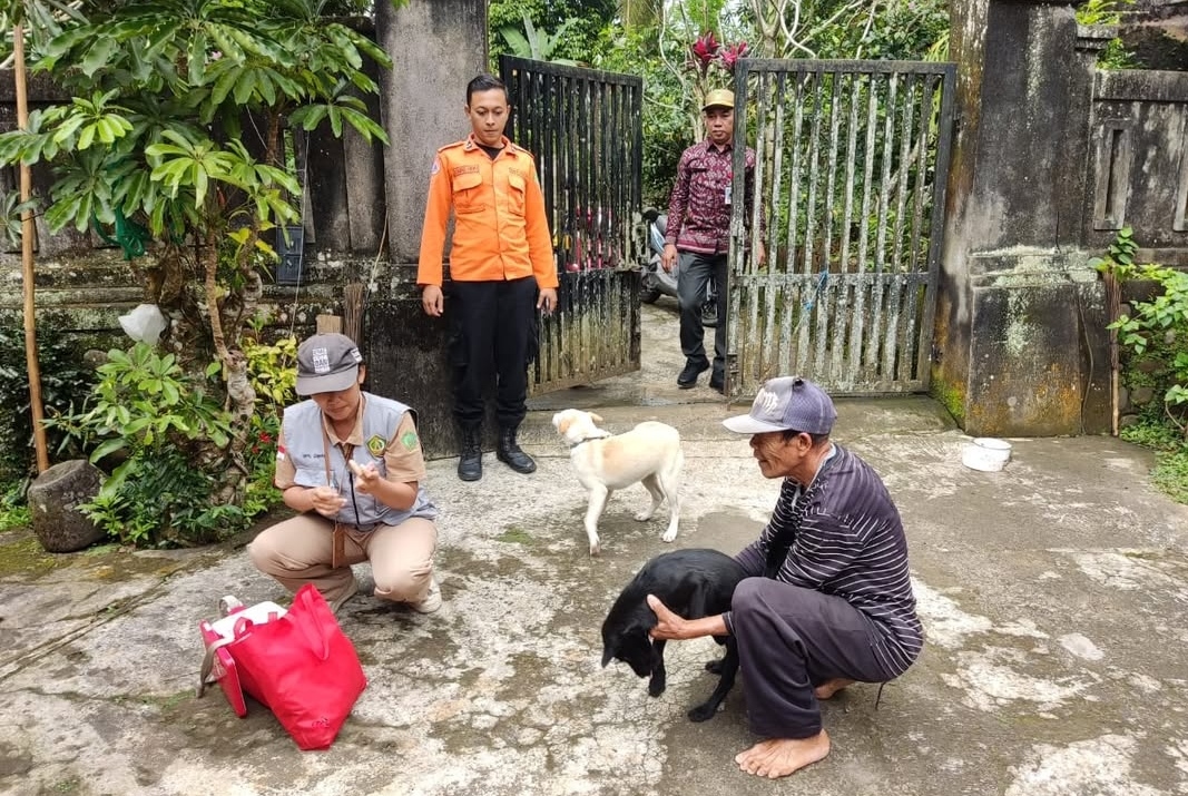 CEGAH RABIES: Petugas melakukan vaksinasi terhadap hewan milik warga guna mencegah rabies.