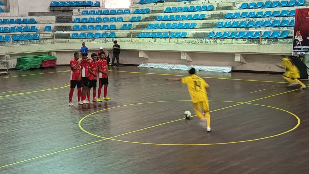 TETAP OPTIMIS: Pemain futsal Buleleng (baju kuning) saat menghadapi tim futsal Gianyar (baju merah) pada babak penyisihan cabor futsal serangkaian Porprov Bali 2025.