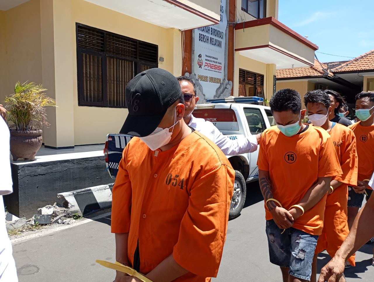 MENUNDUK: Tersangka AP saat dibawa ke sel tahanan Polres Buleleng.