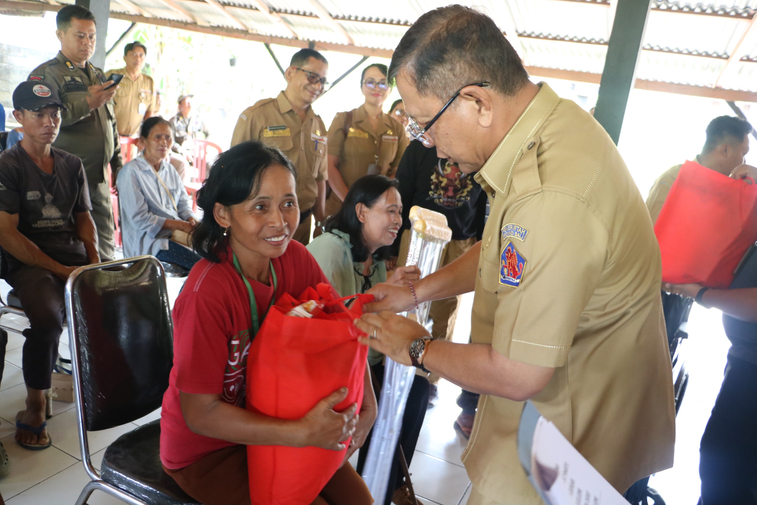 SERAHKAN BANTUAN: Bupati Buleleng, I Nyoman Sutjidra (kanan) menyerahkan bantuan sembako kepada warga dan pemulung di Kelurahan Penarukan