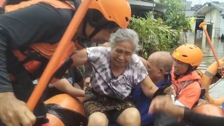 EVAKUASI: Tim SAR melakukan evakuasi terhadap seorang lansia yang terjebak dalam musibah banjir di Denpasar, Bali.