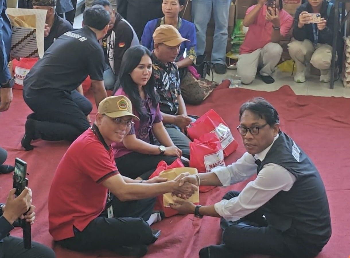 SERAHKAN BANTUAN: Anggota DPR RI, Ketut Kariyasa Adnyana (kanan) saat menyerahkan bantuan kepada warga terdampak musibah banjir.
