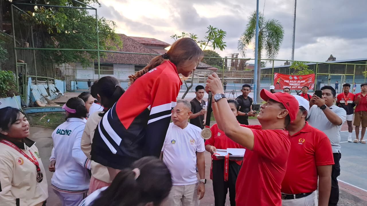 KALUNGKAN MEDALI: Wakil Bupati Buleleng, Gede Supriatna mengalungkan medali kepada atlet tenis lapangan Buleleng yang berhasil meraih medali emas pada Porprov Bali 2025.