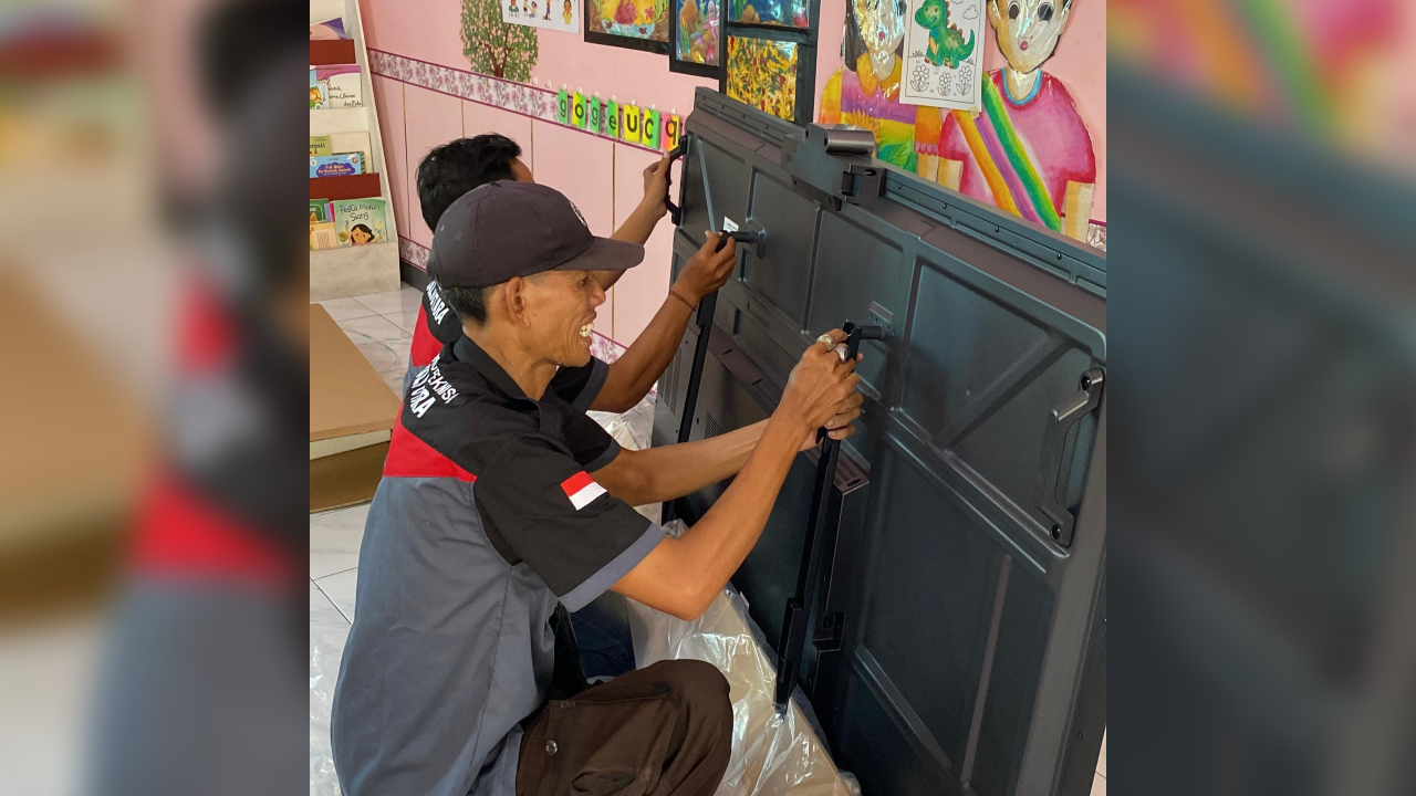 PASANG SMARTBOARD: Teknisi memasang smartboard pada salah satu PAUD di Buleleng.