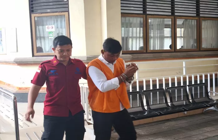 MENANGIS: I Wayan Sudirta (baju oranye) usai menjalani sidang di Pengadilan Negeri Denpasar. Dia dihukum 3 tahun penjara karena menculik seorang bocah.