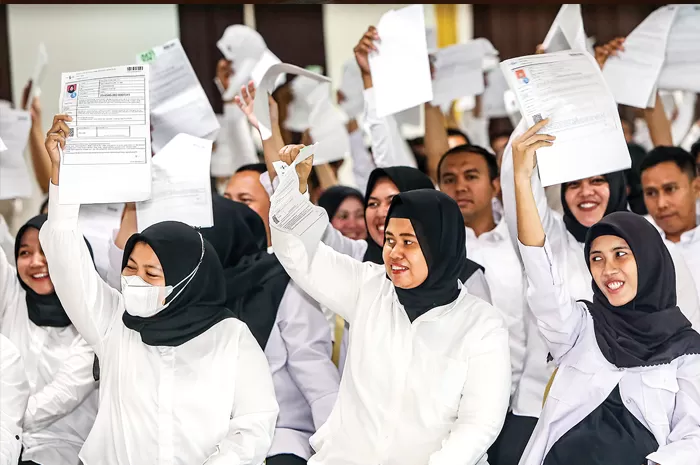 MENUNGGU: Para peserta seleksi calon pegawai pemerintah dengan perjanjian kerja (PPPK) menunjukkan berkas pendaftaran di sela-sela uji kompetensi di Graha Unesa.