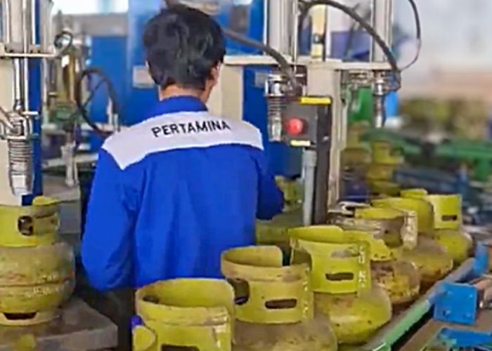 Seorang petugas Pertamina memeriksa tabung LPG 3 kilogram di fasilitas pengisian gas.
