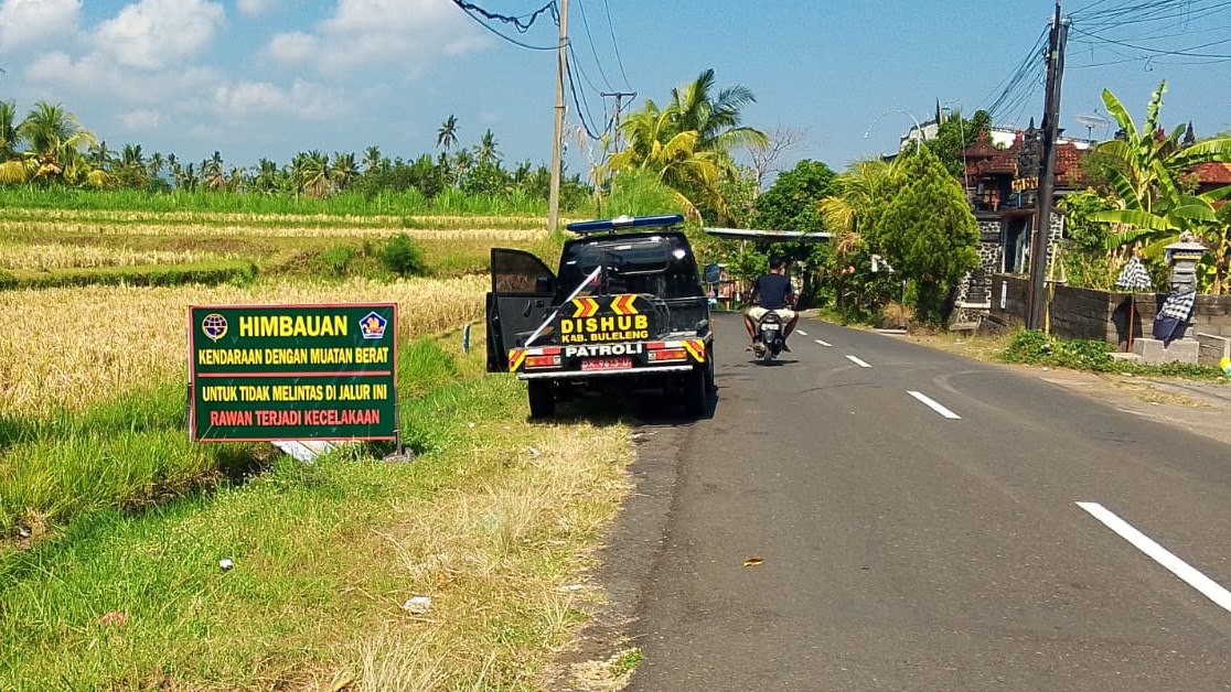 JANGAN LEWAT SINI! Dinas Perhubungan Buleleng memasang spanduk himbauan agar pengemudi kendaraan angkutan barang menghindari jalur ekstrem.