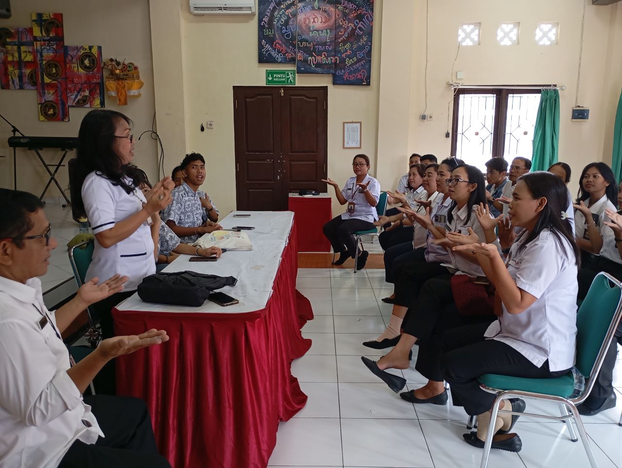 BELAJAR: Staf Dinsos Buleleng belajar bahasa isyarat kepada guru dan siswa di SLB Negeri 1 Buleleng.