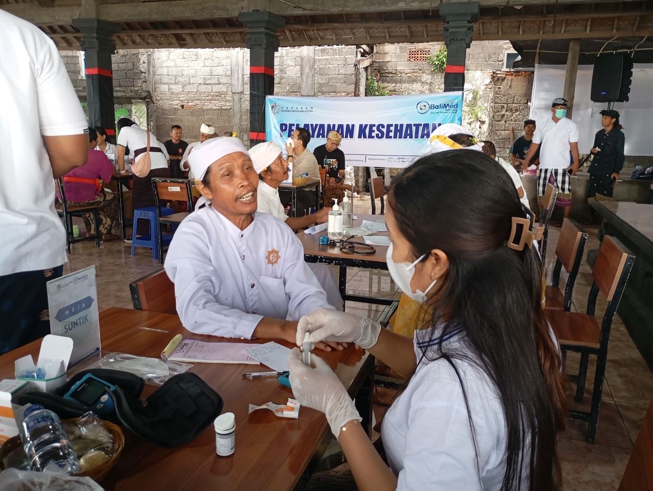 WUJUD KEPEDULIAN: Suasana layanan kesehatan gratis yang dilakukan prajuru untuk pengempon Pura Taman Sari. Ini agar kesehatan mereka tetap terjaga, meski harus ngayah selama piodalan.