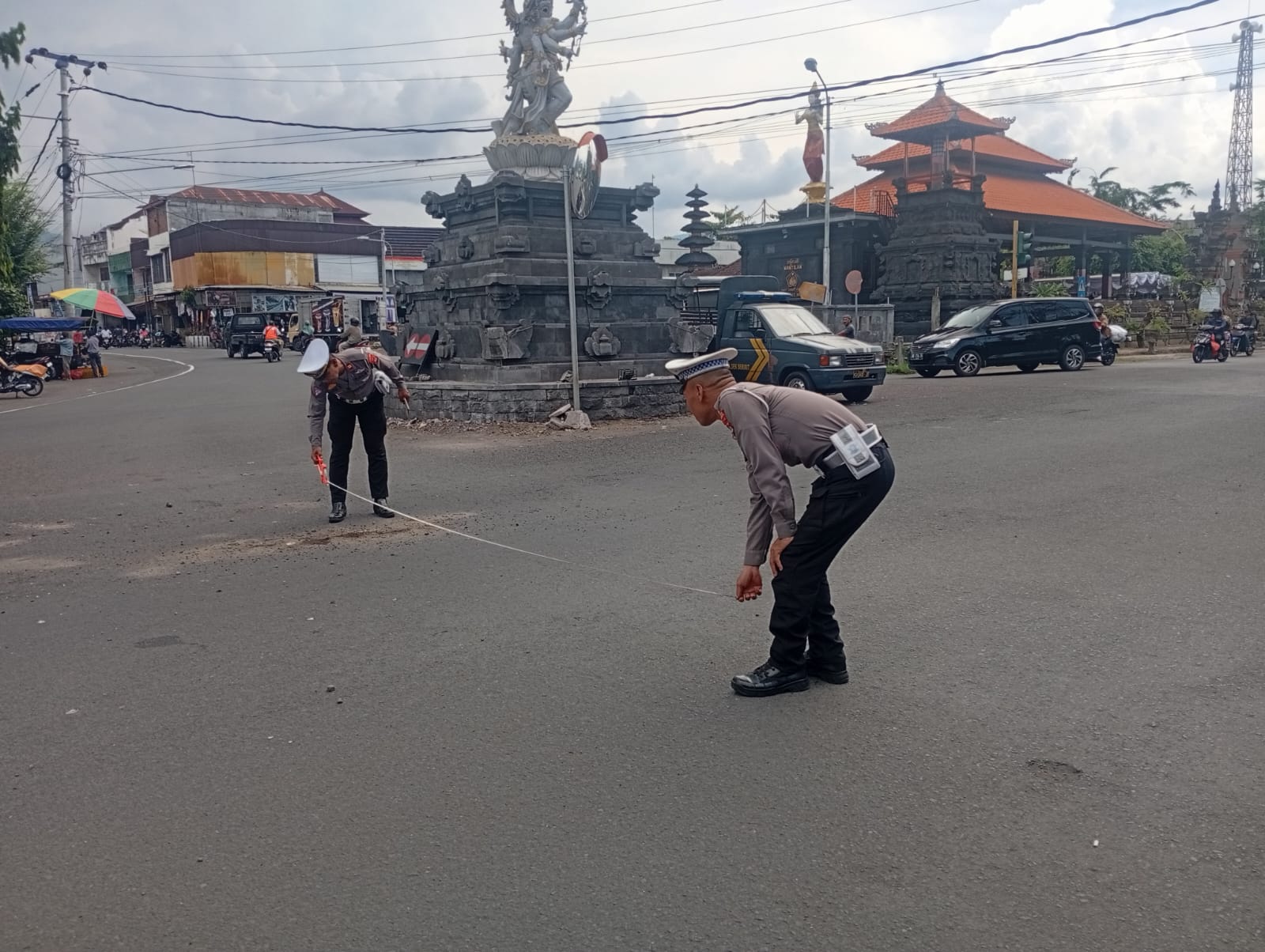 OLAH TKP: Polisi melakukan olah TKP di Jalan Raya Seririt-Singaraja gara-gara truk menerobos lampu merah. Akibat peristiwa tersebut, seorang pengendara motor tewas dan seorang lagi kritis.