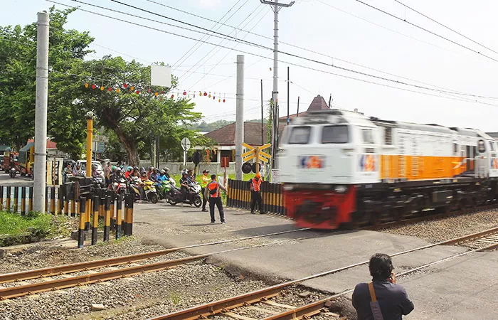 Petugas membersihkan puing-puing mobil yang berserakan usai mengalami kecelakaan dengan kereta 161 Bangunkarta, Sleman, Selasa (4/11/2025).