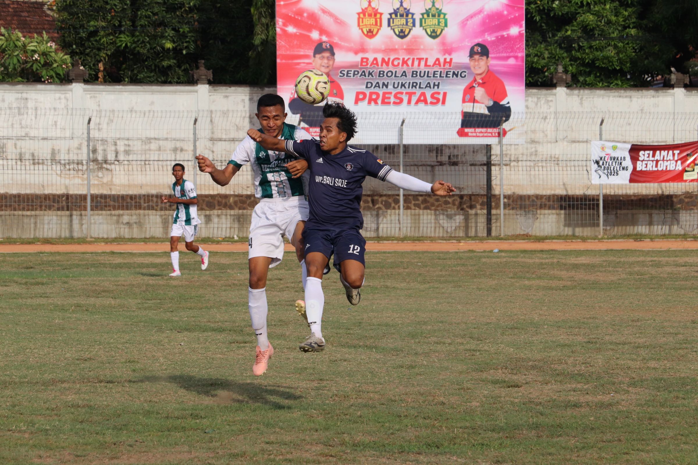DUEL UDARA: Pemain Putra Kubutambahan (baju hijau putih) berebut bola dengan pemain Satria Muda FC Pengulon (baju hitam).