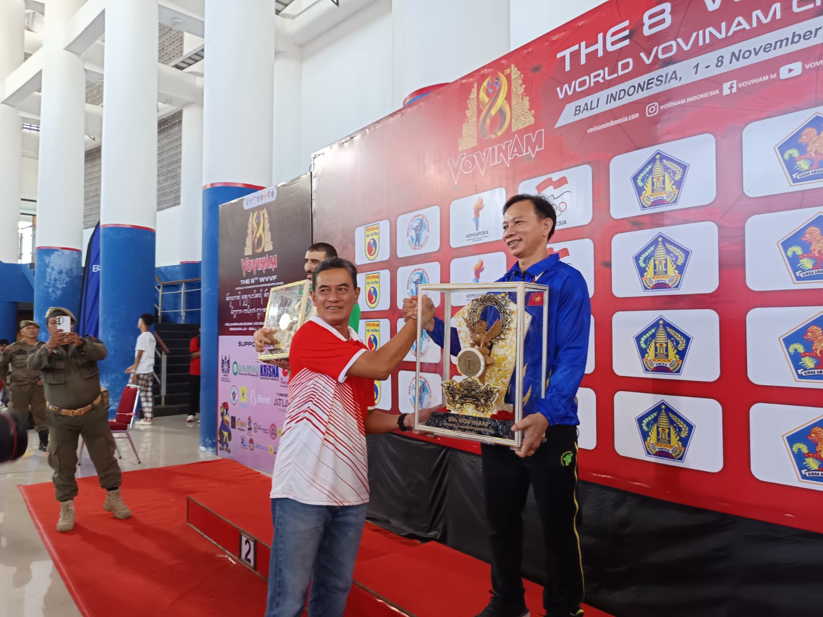 JUARA: Ketua Panitia Kejuaraan Dunia Vovinam 2025, Gede Supriatna (kiri) menyerahkan tropi kepada pimpinan kontingen Vietnam.