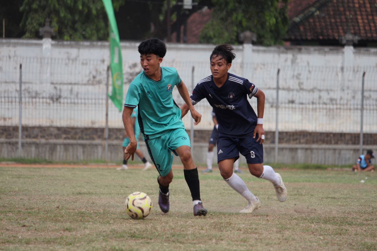 KETAT: Pemain Putra Devata Pakisan (hijau) berhadapan dengan pemain Satria Muda Pengulon (biru).