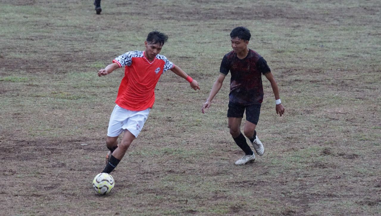 KETAT: Pemain PERS Sangsit (merah) mengawal bola, sementara pemain Persada United (hitam) membayangi. Mereka bermain imbang dalam kompetisi Liga 2 PSSI Buleleng, Rabu (12/11/2025).