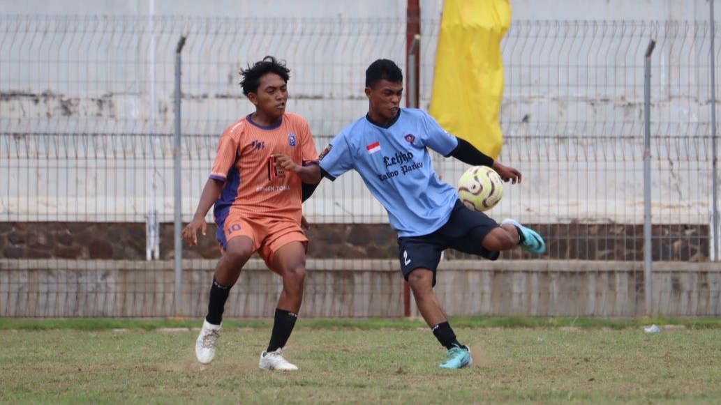 JAGA BOLA: Pemain Putra Kubutambahan (biru) mengawal bola dari pemain Taruna 99 Celukan Bawang (oranye).