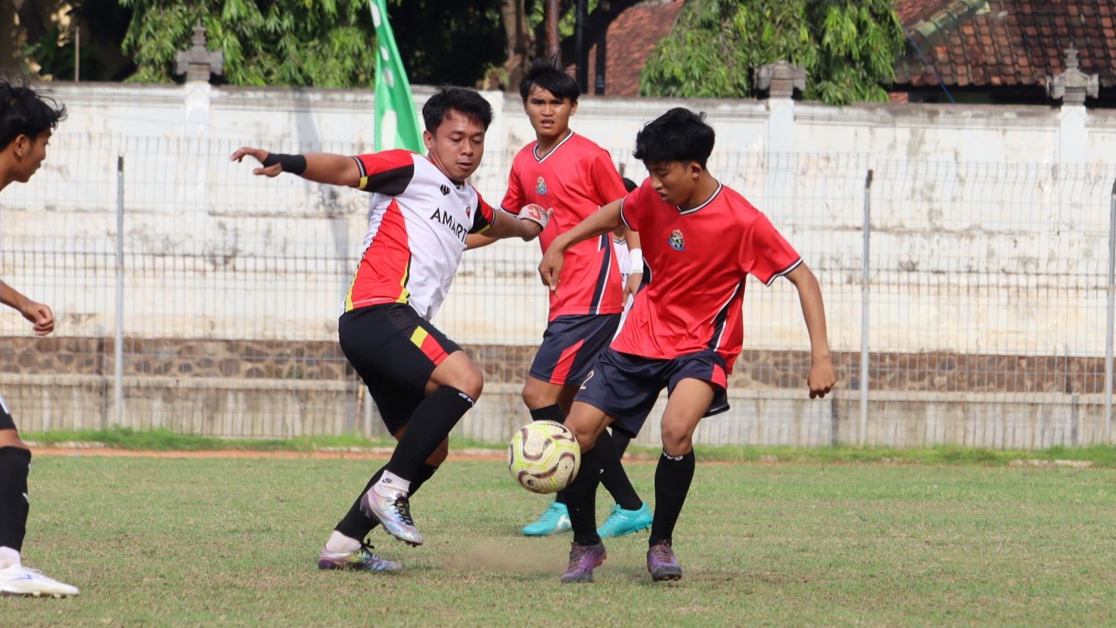 KANS JUARA: Pemain Putra Devata Pakisan (merah) berhadapan dengan pemain Amartha FC Patas (putih).