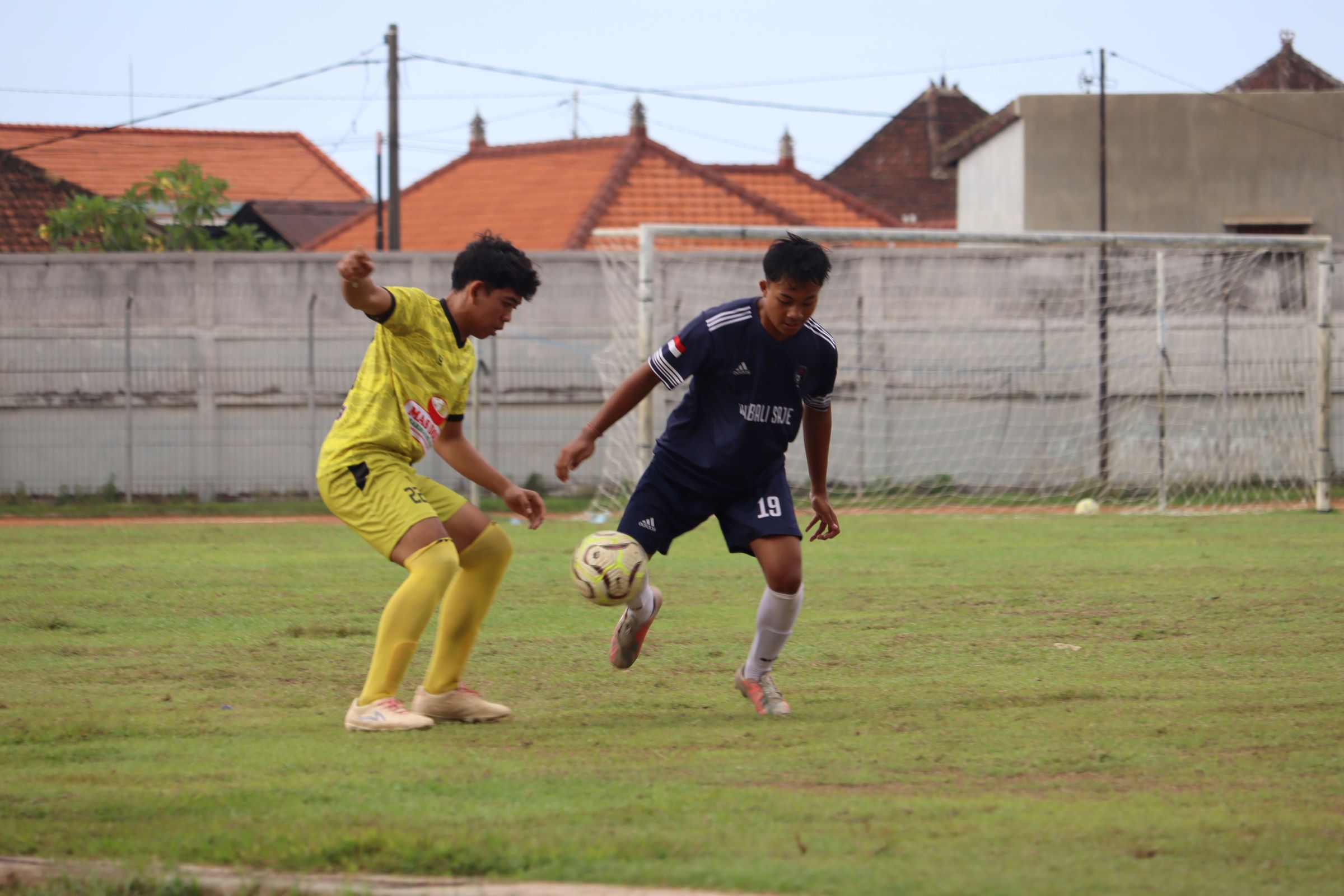 MENANG MEYAKINKAN: Pemain Putra Selayar Kampung Baru (kuning) berebut bola dengan pemain Satria Muda Pengulon (biru tua). Satria Muda berhasil menang dengan skor 3-0 atas Putra Selayar.