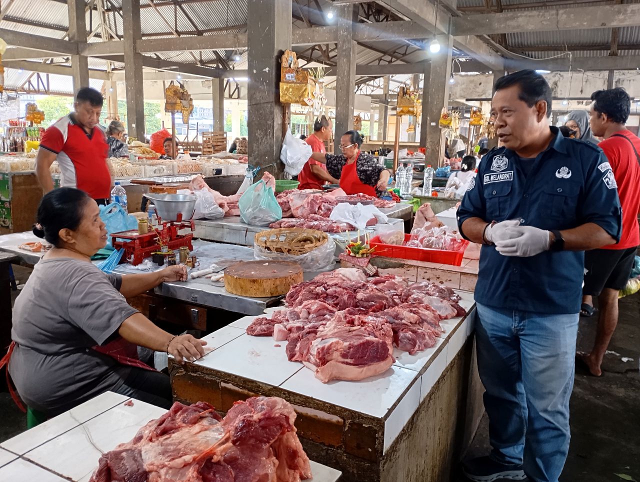 CEK DAGING BABI: Kepala Dinas Pertanian Buleleng, Gede Melandrat (kanan) mengecek daging babi di Pasar Anyar Singaraja.