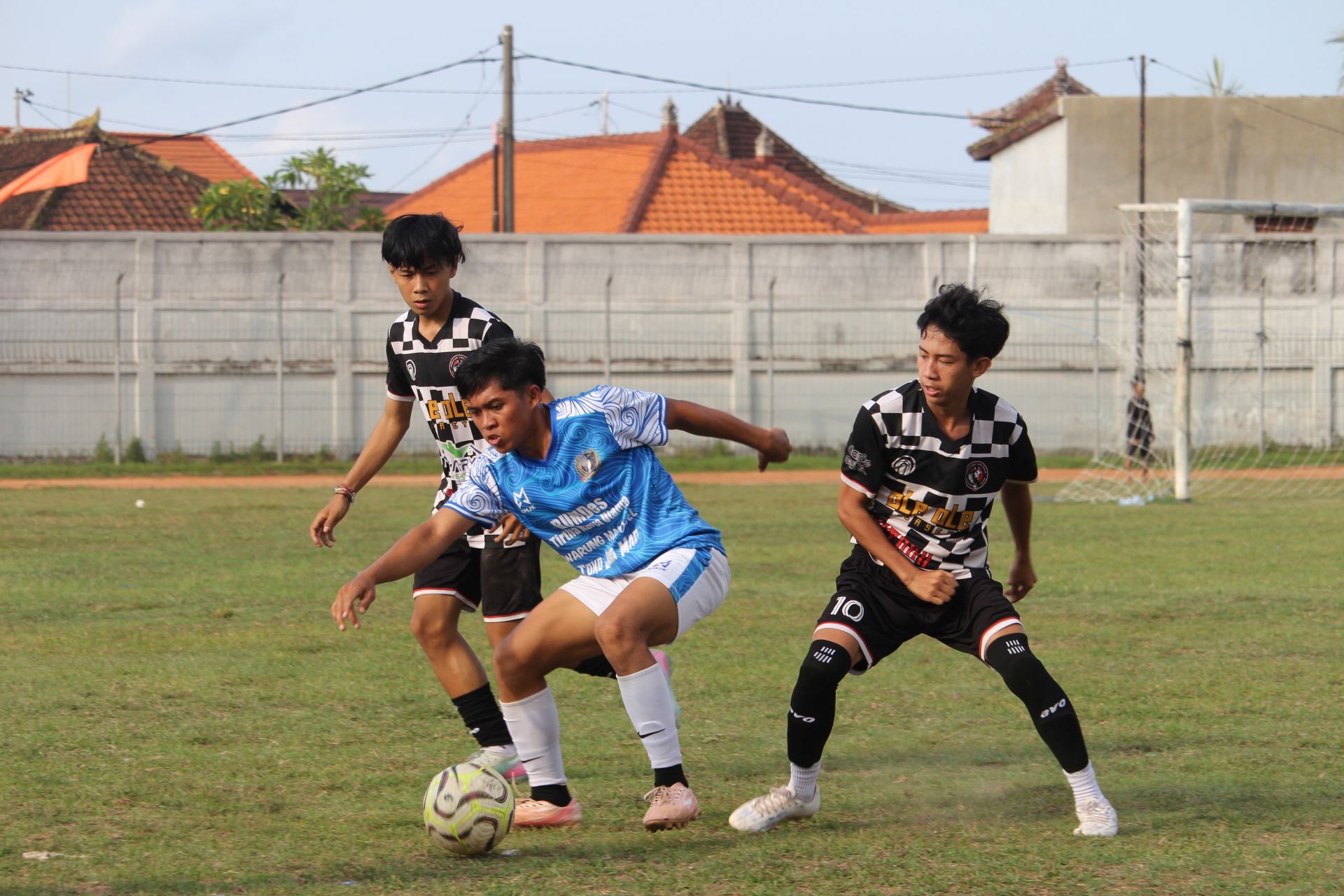 KETAT: Pemain Sukla Bali FC Sumberklampok (biru) berusaha lepas dari tekanan pemain Dorayaki FC Beratan (hitam-putih).