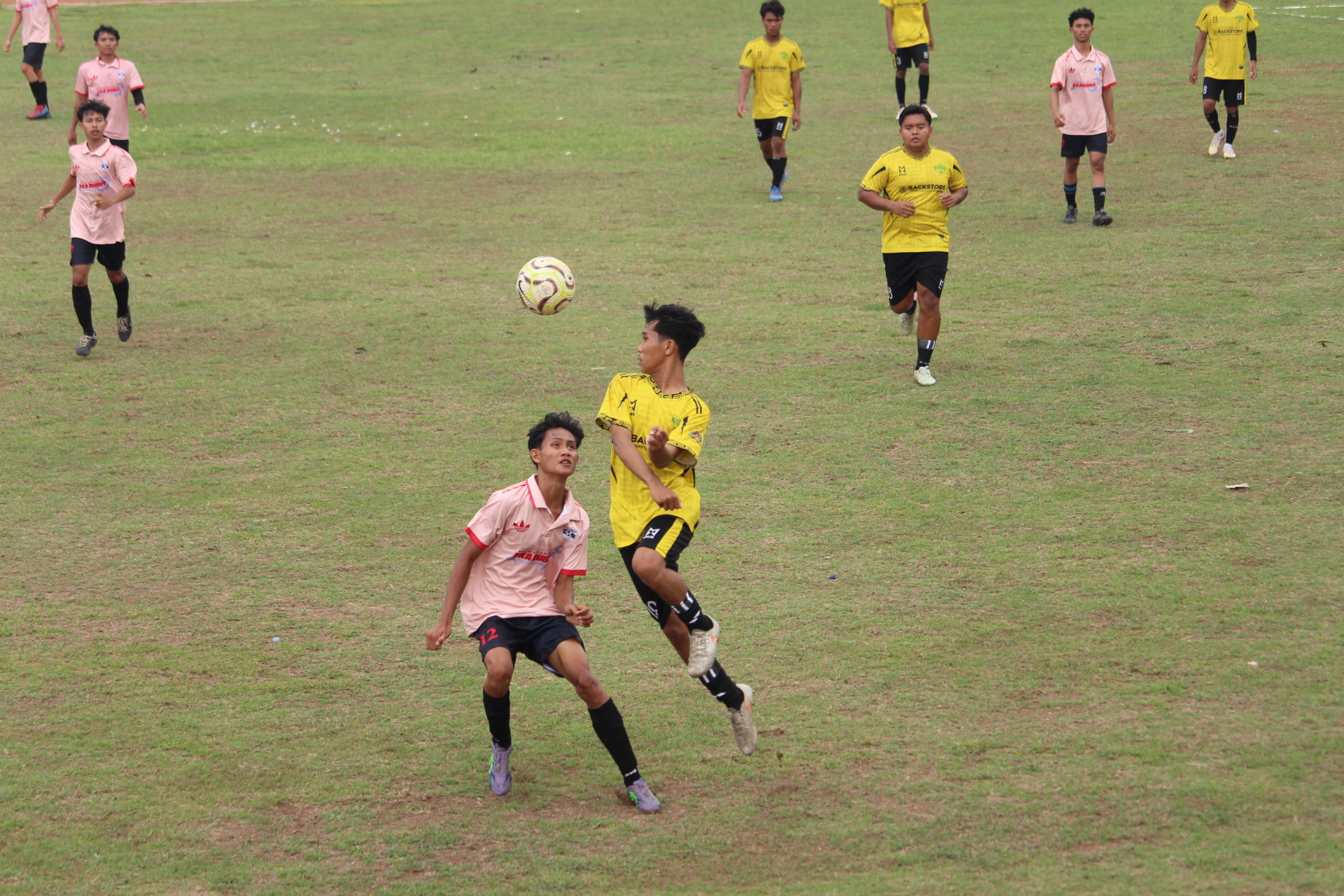 SENGIT: Pemain Putra Fajar (kuning-hitam) berduel memperebutkan bola dengan pemain Persada United (pink-hitam). Putra Fajar berhasil membalikkan keadaan dan menang.