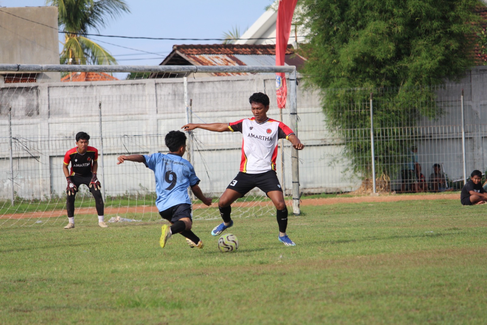 SERU: Pemain Putra Kubutambahan, Wisnu (biru-hitam) berusaha mengeksekusi bola. Namun dihadang Agus Juniawan dari Amartha FC (putih-hitam).