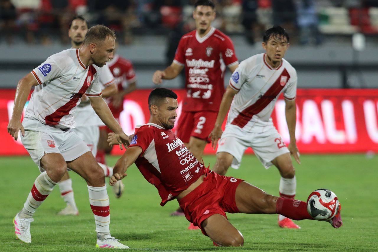 MAIN IMBANG: Pemain Bali United, Boris kopitovic (merah) dibayangi pemain Persis Solo, Xando Dylan Schenk (putih) di Stadion Kapten I Wayan Dipta pada Minggu (23/11/2025).