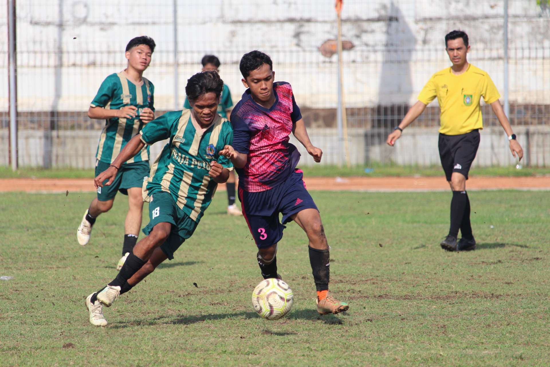 DOMINAN: Pemain Putra Mas Pemuteran (hijau) berebut bola dengan pemain Sekeling FC Penyabangan (merah) dalam Liga 3 PSSI Buleleng.