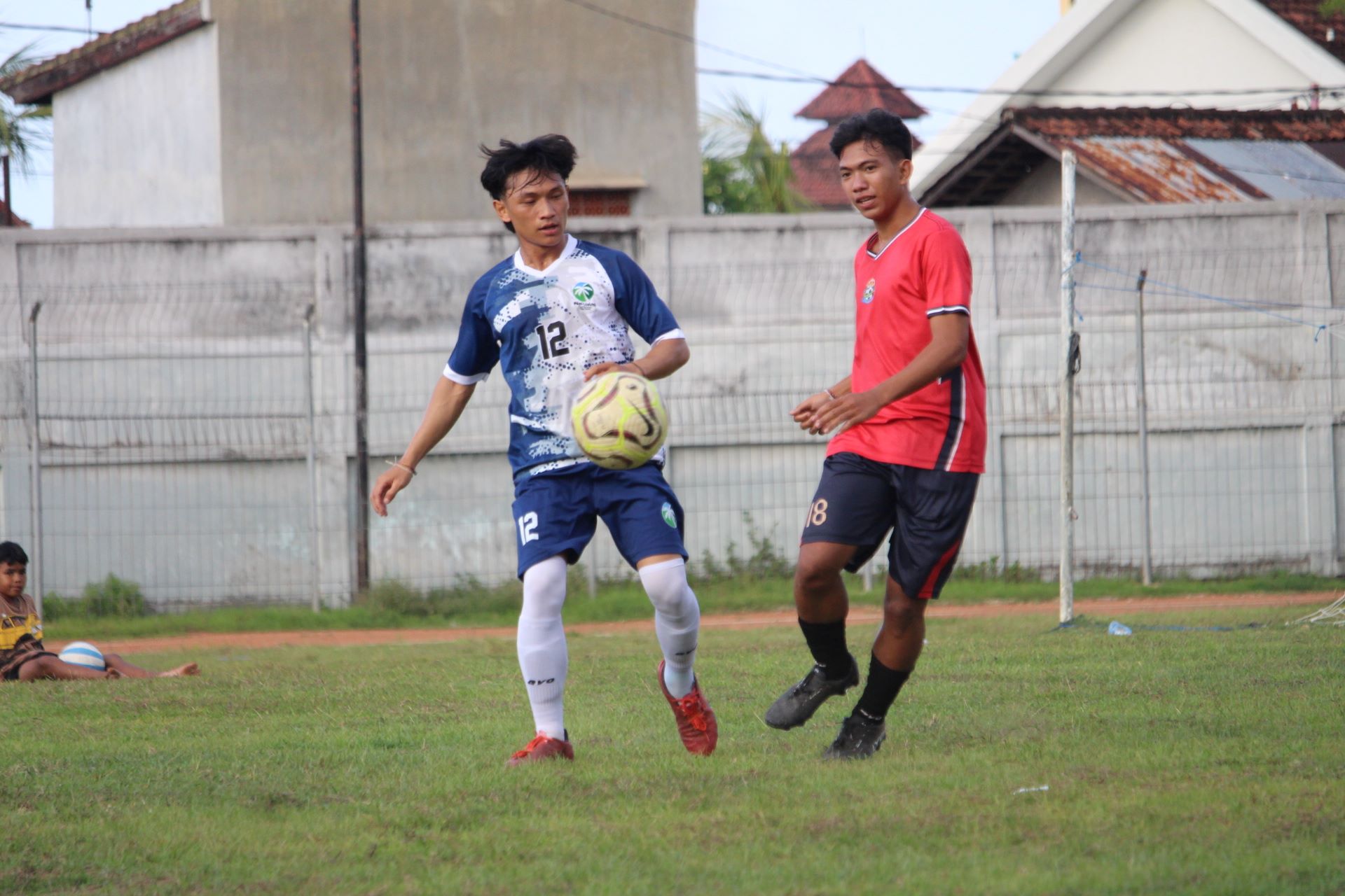 MAKIN KOKOH: Pemain Putra Devata Pakisan (merah) saat berhadapan dengan pemain Forkal Kalibukbuk (biru) pada kompetisi Liga 1 PSSI Buleleng, Kamis (27/11/2025).