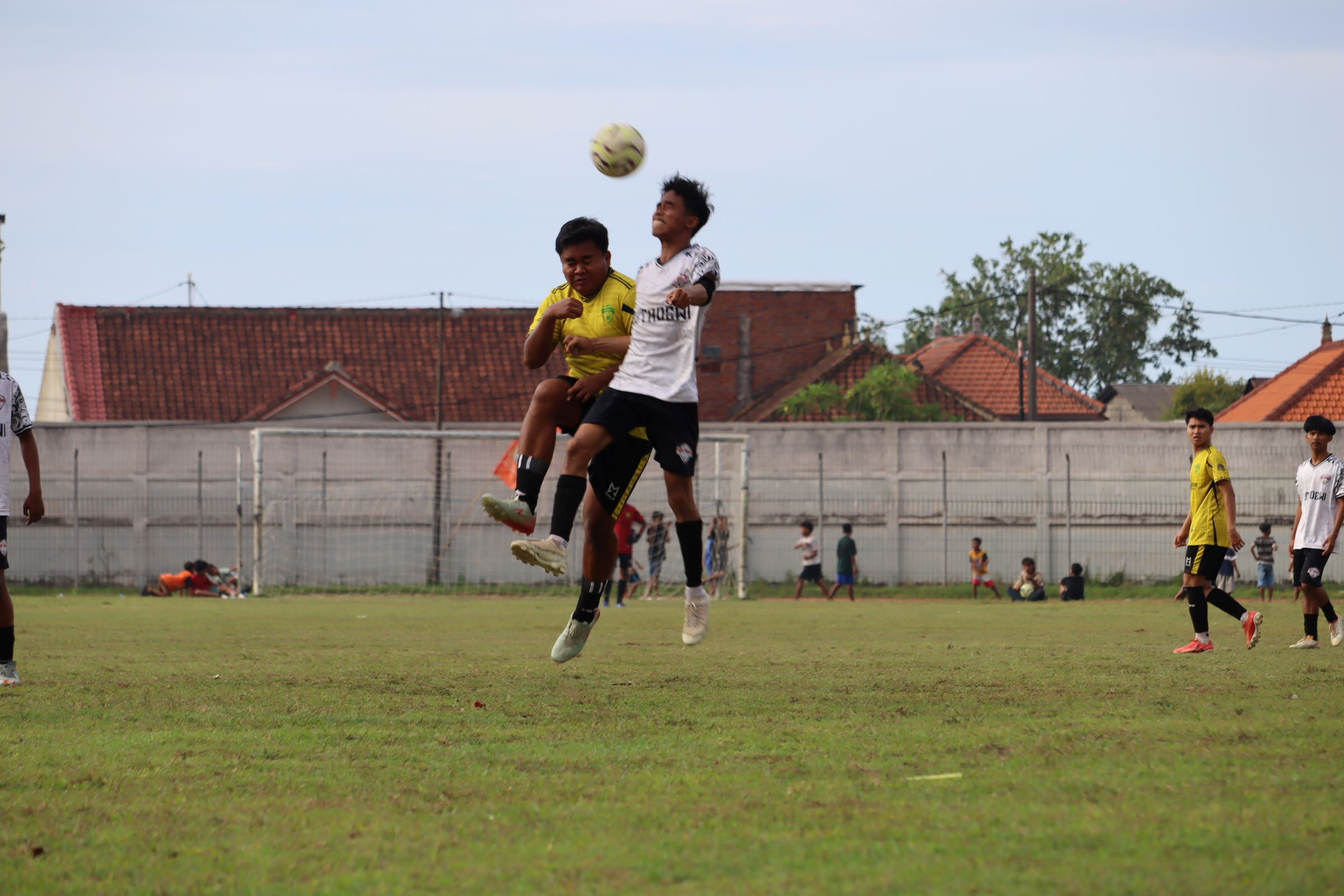 DUEL: Pemain Putra Fajar Patas (kuning) saat berduel berebut bola dengan pemain PERS Sangsit (putih) di Stadion Mayor Metra Singaraja, Sabtu (29/11/2025).