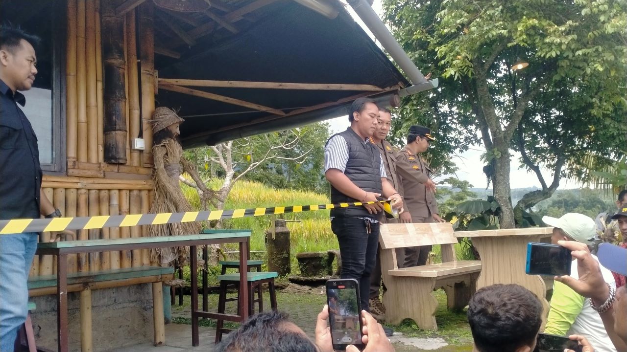 SEGEL: Pol PP memasang garis tanda penyegelan bangunan di kawasan DTW Jatiluwih.