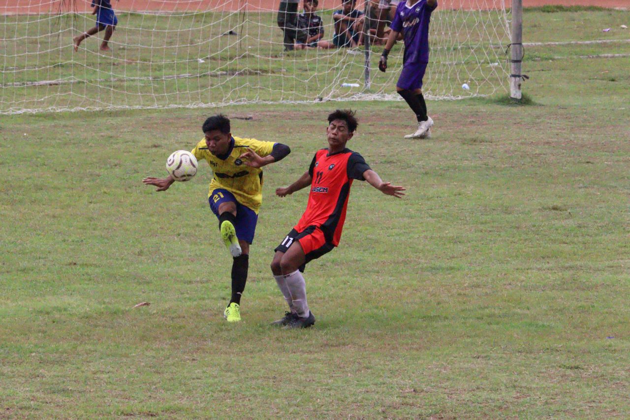 BEREBUT BOLA: Pemain Tunas Muda Celukan Bawang (kuning) merebut bola dari pemain Putra Harapan Kaliasem (merah) dalam pertandingan di Stadion Mayor Metra Singaraja, Selasa (2/12/2025).