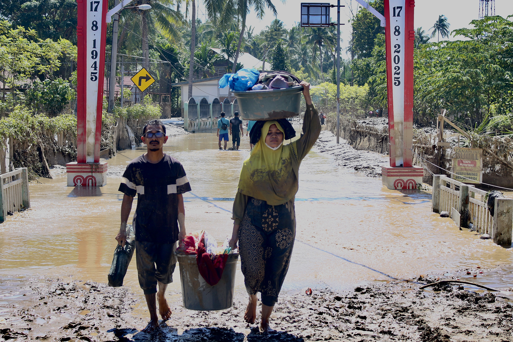 Sejumlah warga membawa sembako di tengah aliran banjir di kawasan Meureudu, Pidie Jaya.