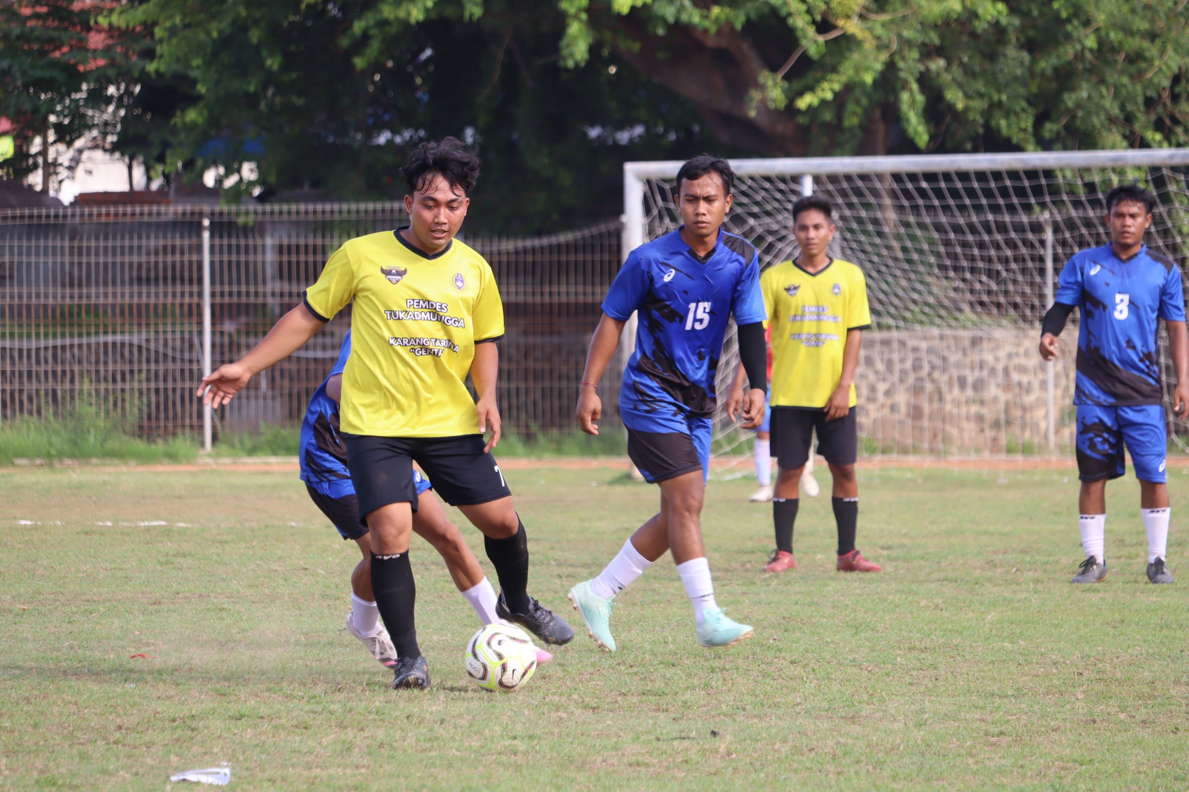 MAIN IMBANG: Pemain Padma Tukadmungga (kuning) berhadapan dengan Tintin Tinga-Tinga dalam pertandingan di Stadion Mayor Metra Singaraja, Senin (8/12/2025).