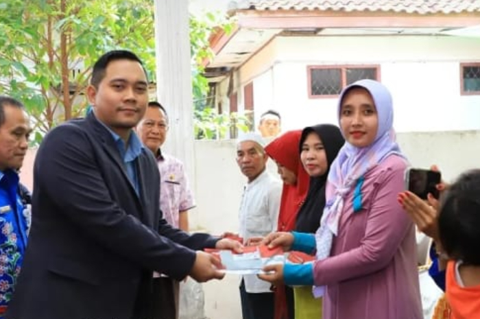 Ilustrasi penyerahan Kartu Keluarga Sejahtera kepada peserta penerima bansos.