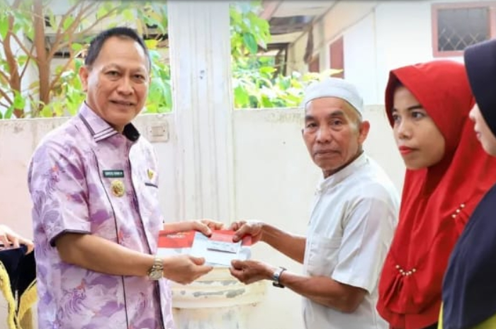 Ilustrasi penyerahan Kartu Keluarga Sejahtera kepada peserta penerima bansos.