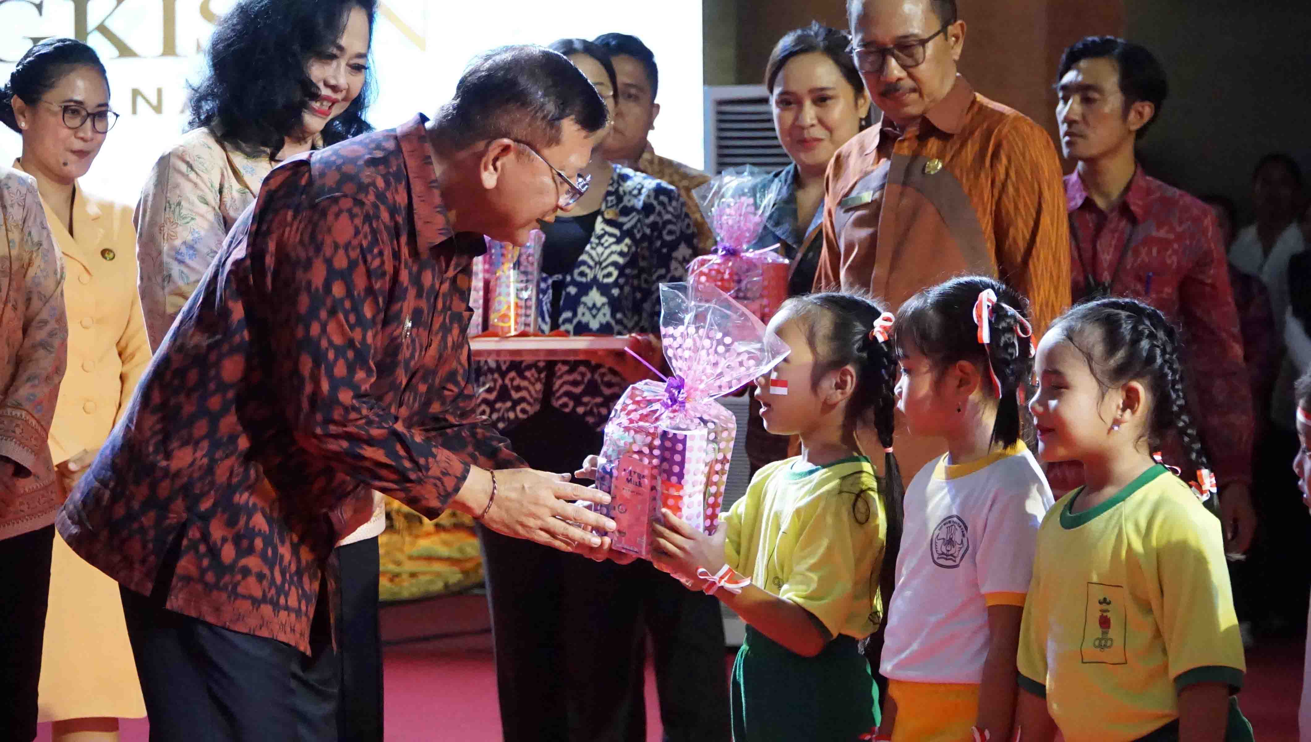 BERI BINGKISAN: Bupati Buleleng, I Nyoman Sutjidra menyerahkan bingkisan kepada siswa PAUD dalam peringatan HUT Dharma Wanita.