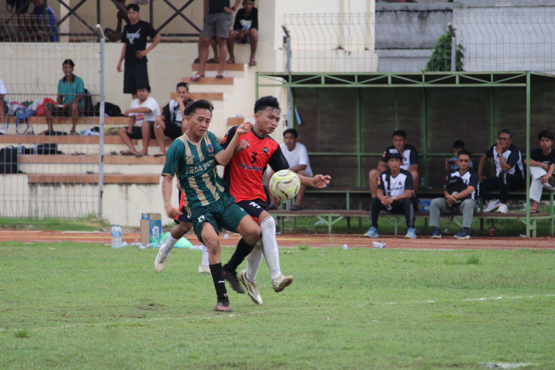 MENANG BESAR: Pemain Putra Mas Pemuteran (hijau) berduel memperebutkan bola dengan pemain Putra Harapan Kaliasem (merah) dalam pertandingan, Jumat (19/12/2025).