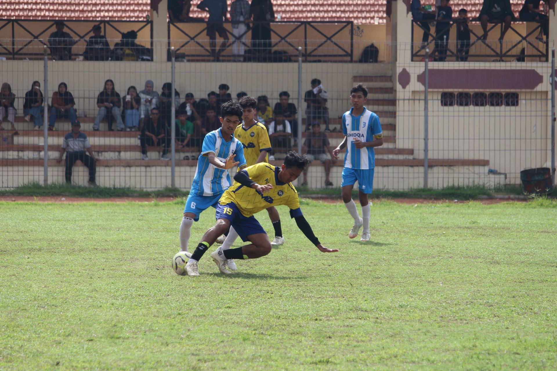 REBUT BOLA: Pemain Intan Jaya Celukan Bawang (biru) berusaha merebut bola dari pemain Tunas Muda Celukan Bawang (kuning) dalam pertandingan Minggu (21/12/2025).