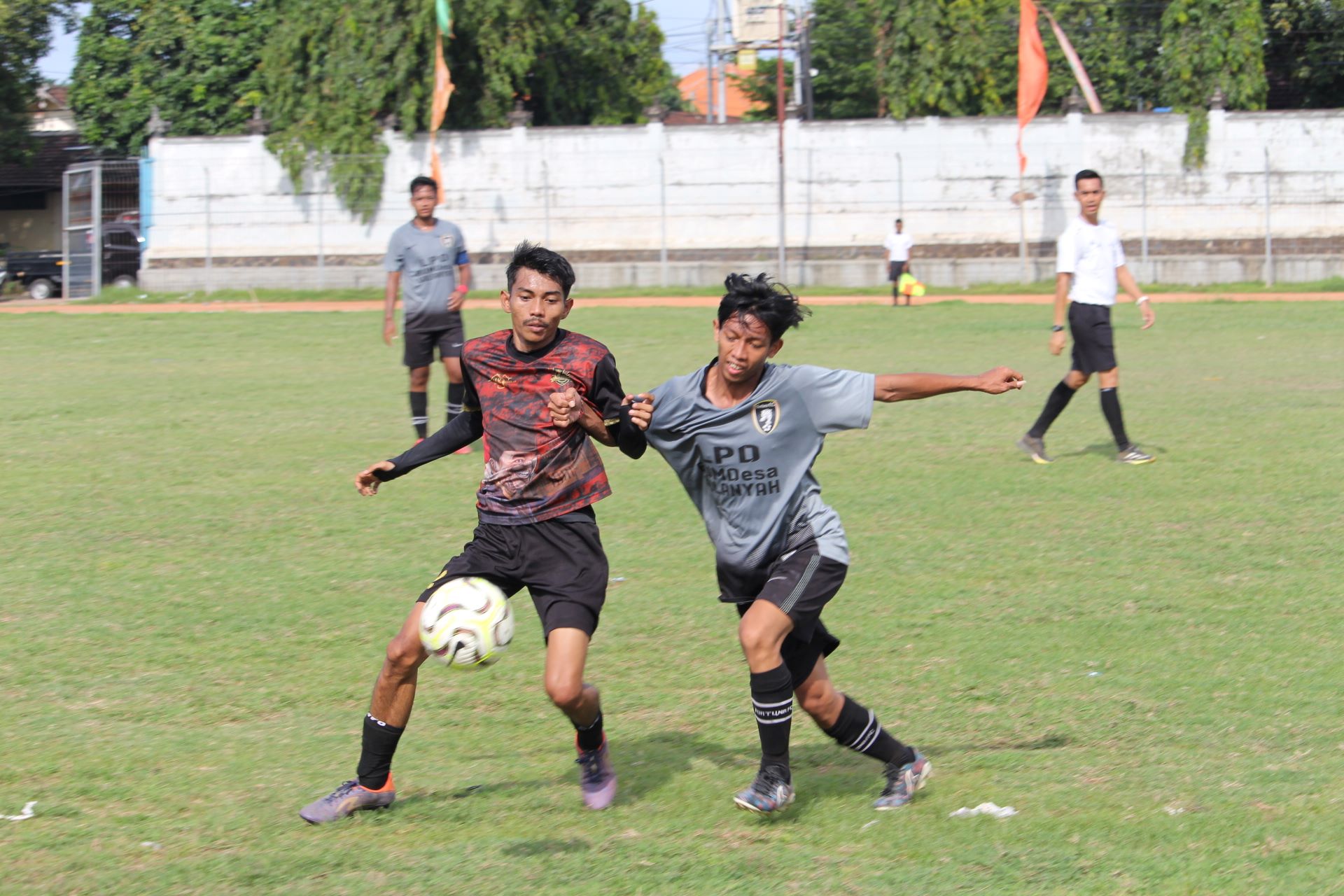 KETAT: Pemain Persada United Sukasada (merah) berusaha mempertahankan bola dari pemain Fortuna FC Sulanyah (abu-abu) dalam pertandingan Rabu (24/12/2025).