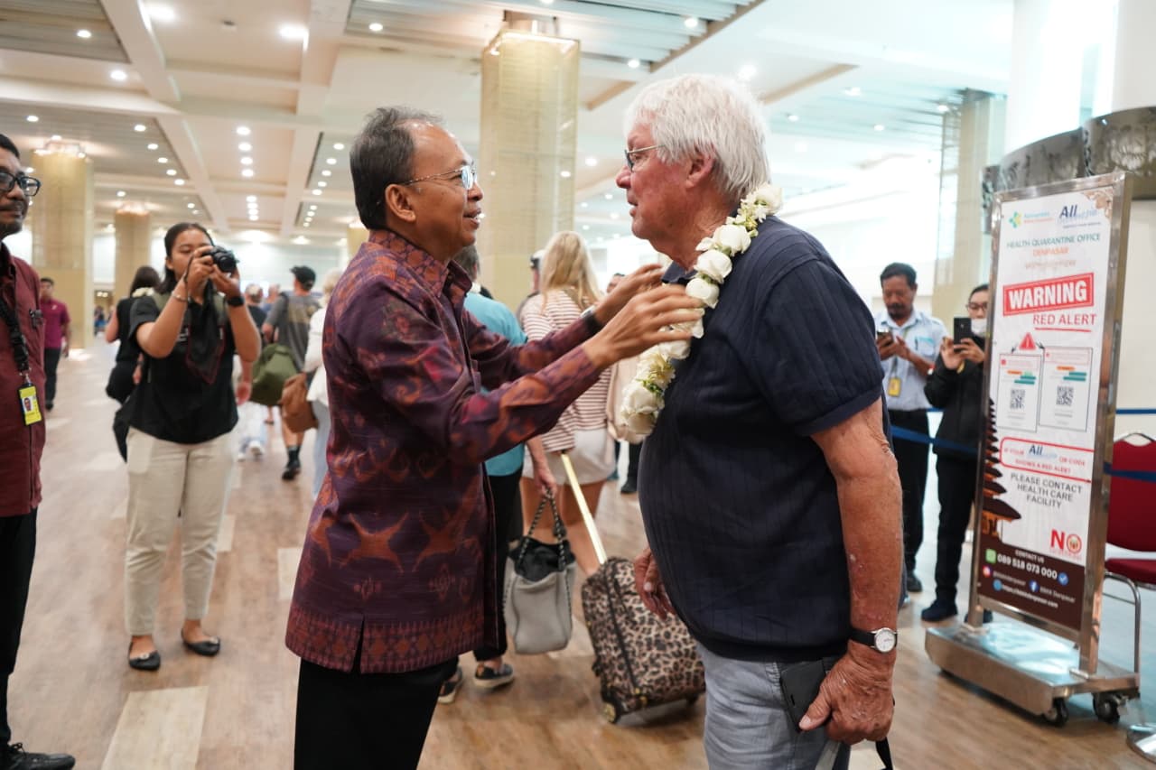 TEMUI WISATAWAN: Gubernur Bali, Wayan Koster, menemui wisatawan di Bandara Ngurah Rai, Minggu (28/12/2025).