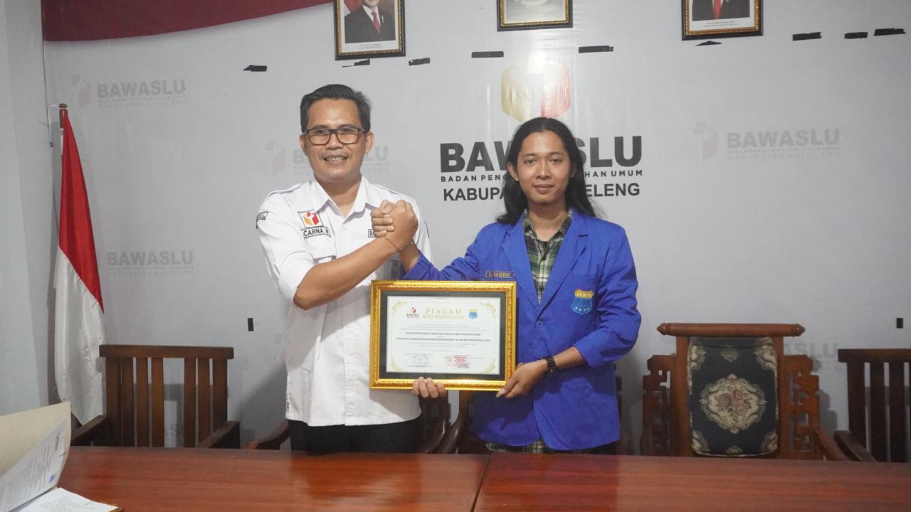 KERJASAMA: Ketua Bawaslu Buleleng, Kadek Carna Wirata (kiri) bersama Ketua PMII Buleleng, Fauzi Hariri usai menandatangani kesepakatan bersama.